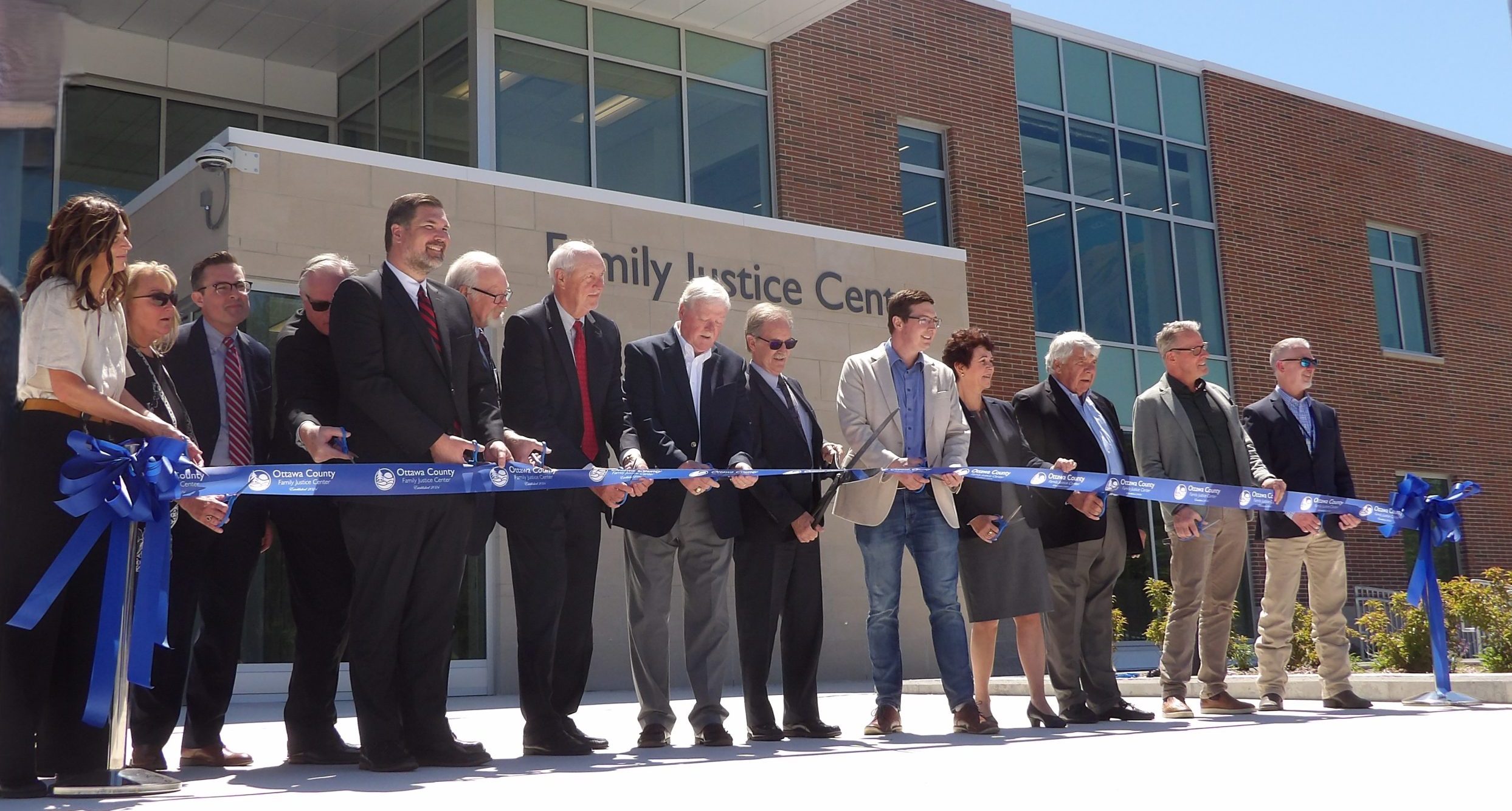 KODAK Digital Still Camera Group of officials in front of family justice center building cutting the ribbon.