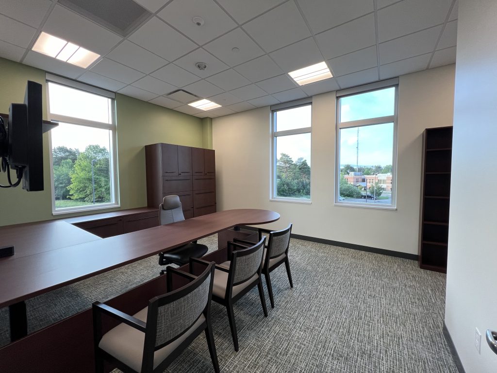 Judges chambers with a dark desk and upholstered chairs